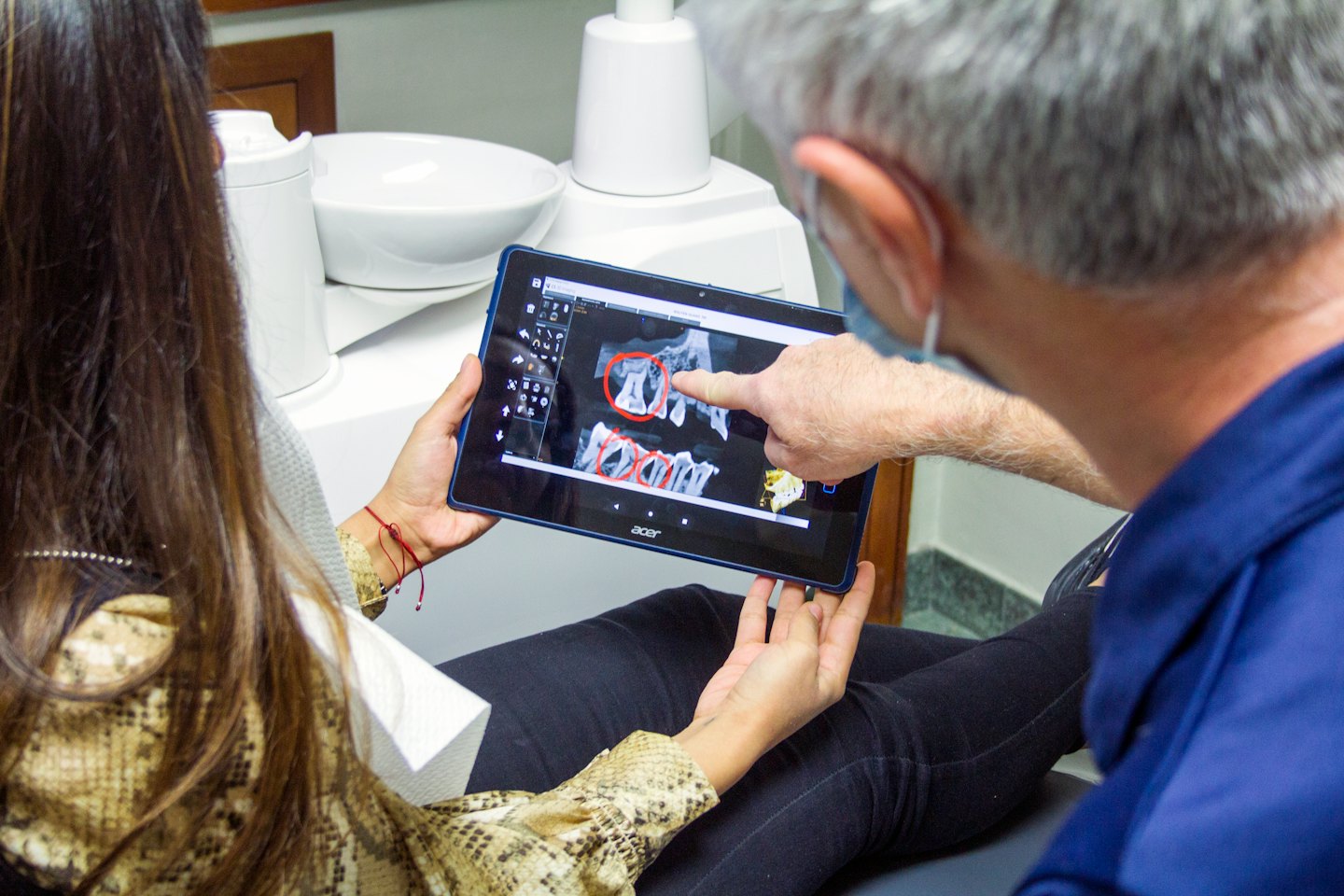Dentista che mostra al paziente una radiografia dentale su un tablet.